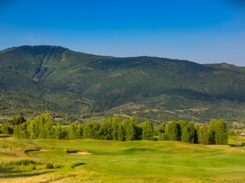 Golf hole with ski hill in background